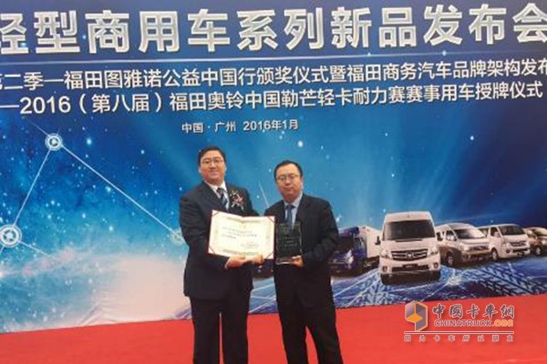 中國下一代教育基金秘書長可勒向福田汽車集團創(chuàng)意總監(jiān)、商務(wù)汽車品牌總監(jiān)韓鵬授予“七彩書屋”公益活動獲獎獎牌