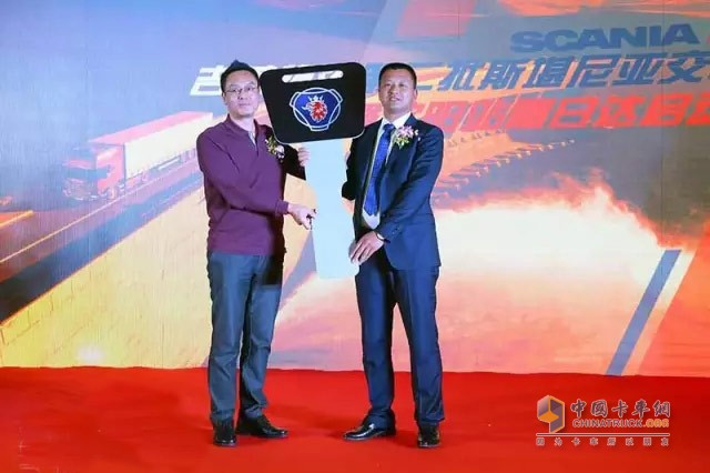 四川豪力汽車銷售有限公司總經(jīng)理黎明賓將鑰匙交付給吉蓉物流董事長(zhǎng)謝汝波