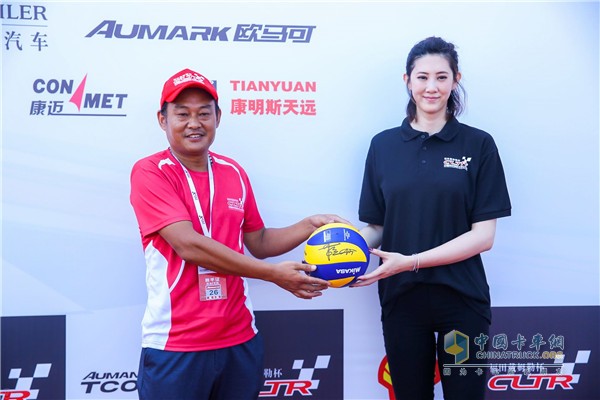 “歐曼卡車人助學(xué)公益計劃”公益大使、前中國女排世界杯冠軍成員薛明為卡車人送禮品