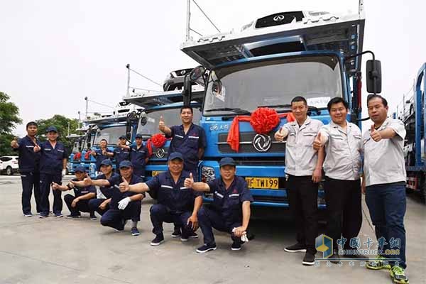 工作人員與東風(fēng)天錦中置軸轎運(yùn)改裝車合影留念
