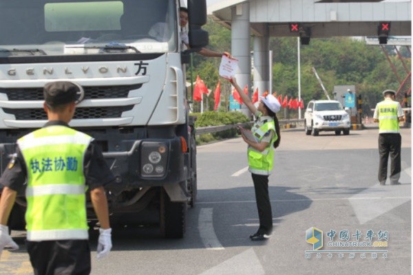G65巴南收費站，交通執(zhí)法人員向接受檢查的貨車駕駛員發(fā)放安全出現(xiàn)宣傳頁