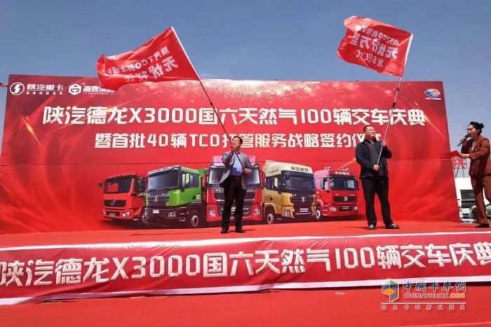 陜重汽銷售公司副總經(jīng)理王永鋒與大客戶高總揮舞大旗，正式開啟發(fā)車儀式