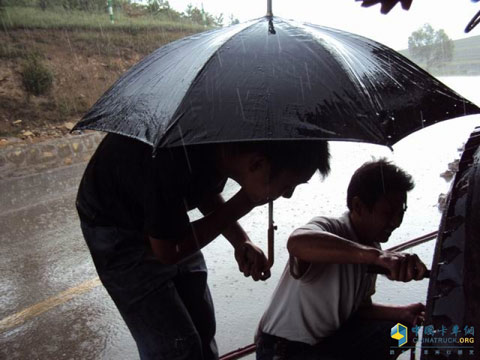 陜汽大飛達(dá)服務(wù)站的李澤平師傅冒雨為用戶修車