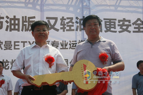 山東同鑫源汽車銷售有限公司總經(jīng)理付福元與山東翔龍煤炭洗選有限公司副總汪明勤(右)交付售后服務(wù)車輛鑰匙